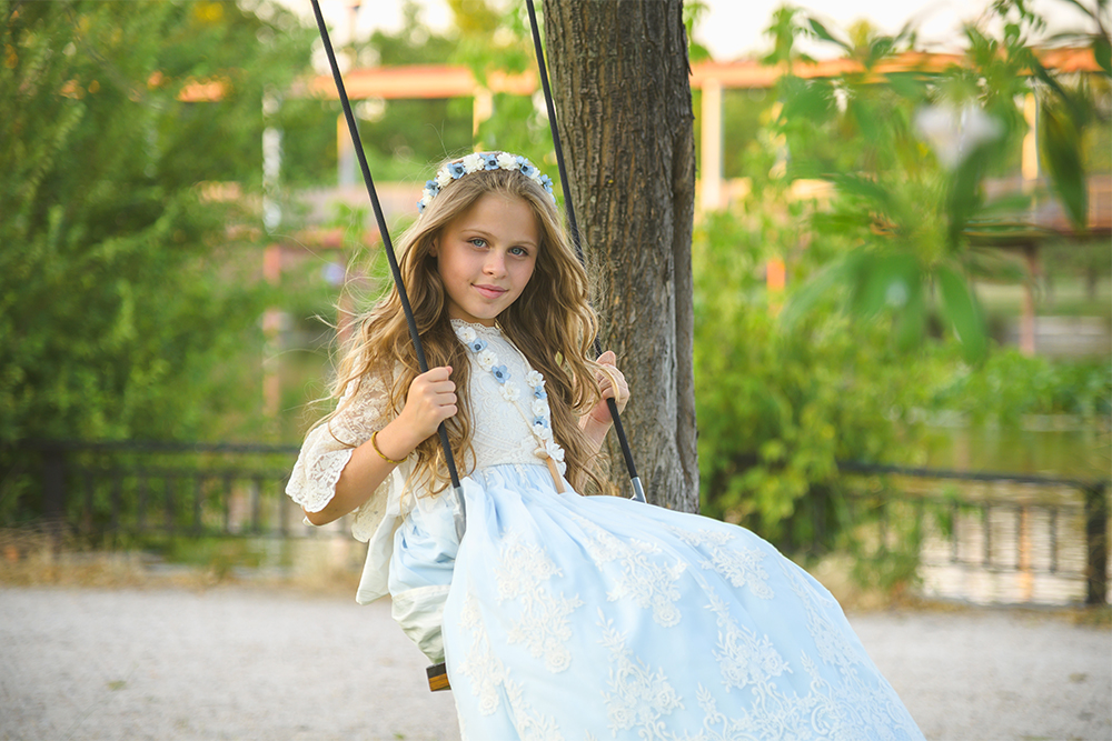 Niña en su sesión de fotos de comunión en un columpio de madera en Madrid, cerca de Villaviciosa de Odón, Boadilla, Alcorcón y Móstoles.