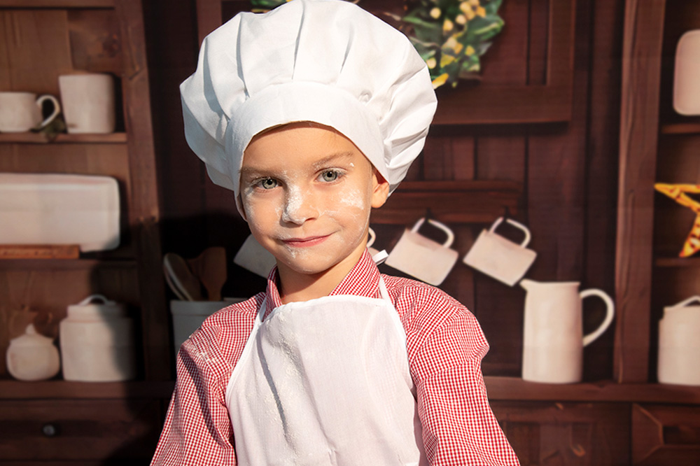 Sesión de fotos infantil divertida: niño jugando con harina en la cocina de Navidad en Alcorcón.